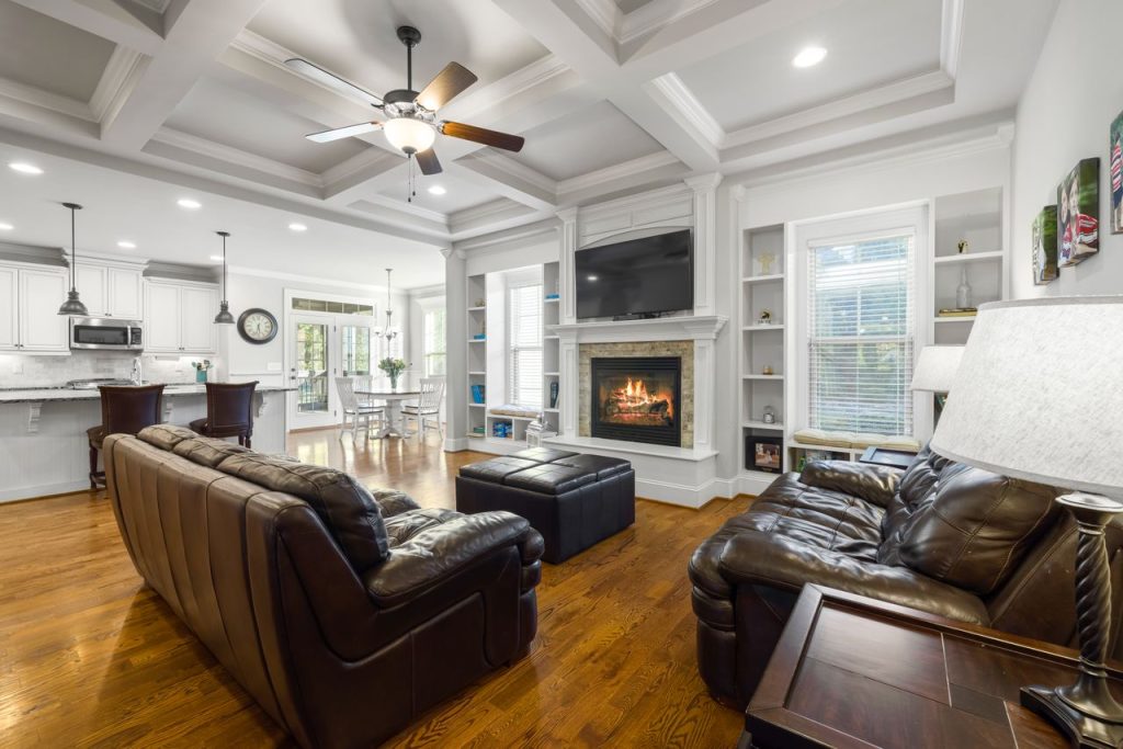 Spacious modern living room featuring leather sofas, a cozy fireplace, and elegant interior design.
